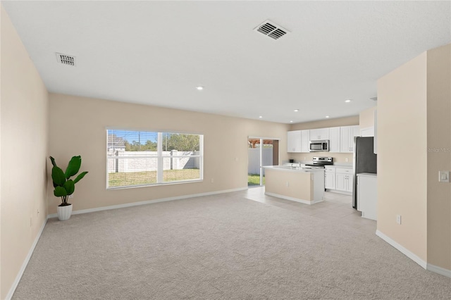 unfurnished living room featuring recessed lighting, visible vents, baseboards, and light colored carpet