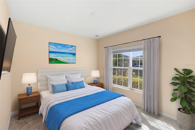 bedroom with light colored carpet and baseboards