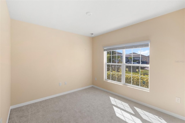 empty room with baseboards and carpet