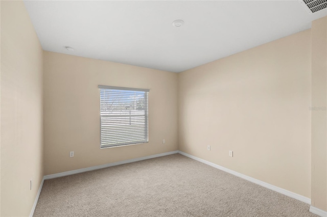 carpeted empty room featuring baseboards and visible vents