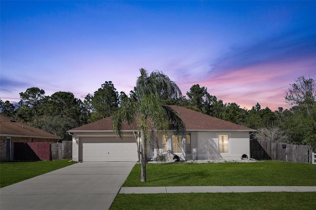 single story home with stucco siding, concrete driveway, a lawn, and fence