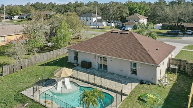 back of house featuring a residential view, central AC unit, a lawn, a fenced backyard, and a patio area