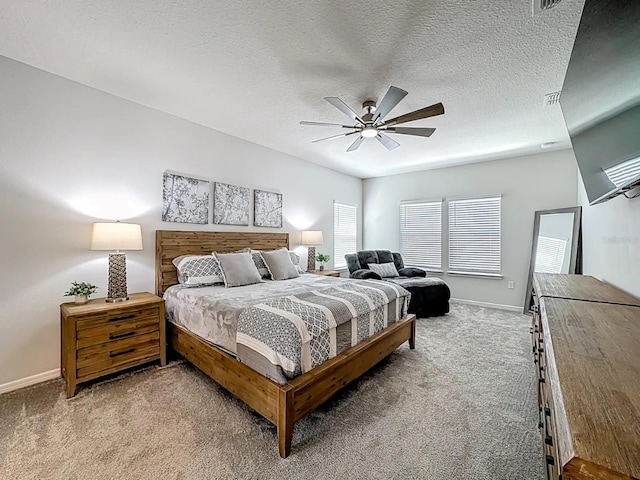 carpeted bedroom featuring visible vents, a ceiling fan, baseboards, and a textured ceiling