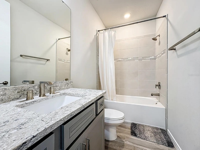 bathroom with shower / bathtub combination with curtain, toilet, wood finished floors, baseboards, and vanity