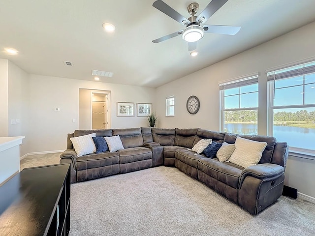 living area featuring carpet flooring, visible vents, a water view, and baseboards