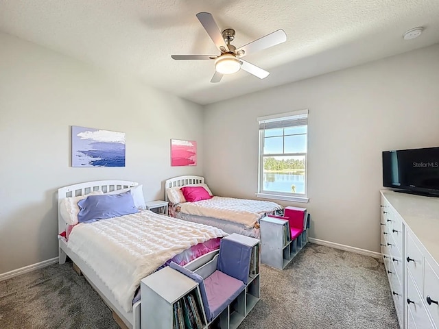 bedroom featuring light colored carpet, baseboards, and a textured ceiling