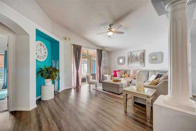 living room featuring decorative columns, a textured ceiling, wood finished floors, and a ceiling fan