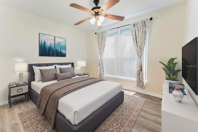 bedroom featuring ceiling fan, baseboards, and light wood-style floors