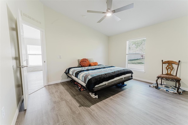 bedroom featuring visible vents, baseboards, wood finished floors, and vaulted ceiling