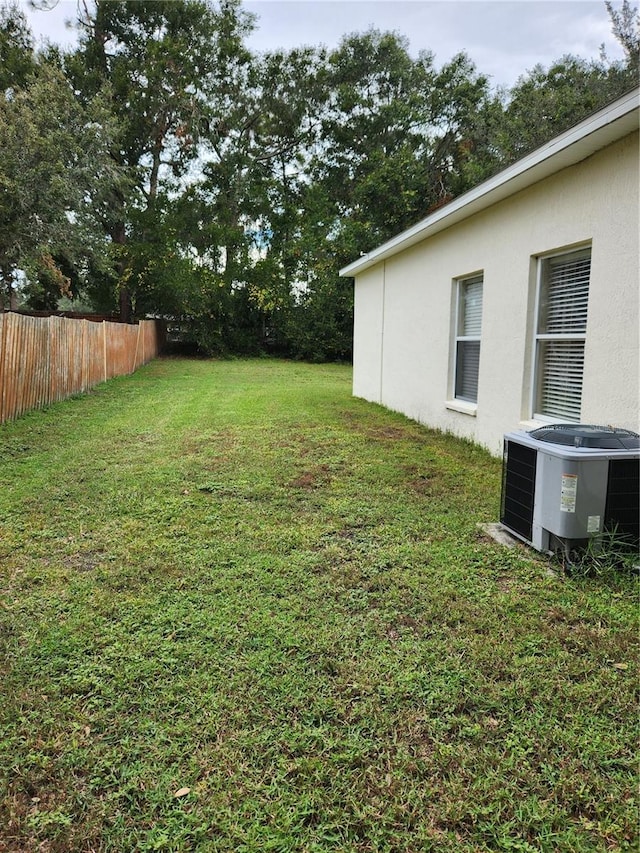 view of yard featuring central air condition unit and fence