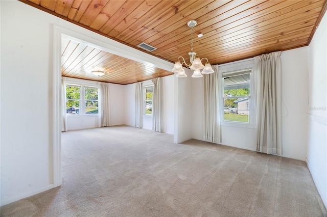 carpeted empty room with wooden ceiling, baseboards, visible vents, and a chandelier