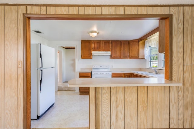 kitchen with visible vents, under cabinet range hood, light countertops, white appliances, and a sink