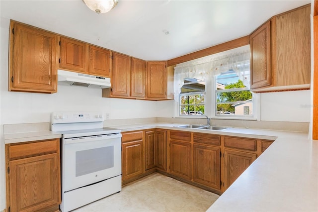 kitchen featuring white electric range, under cabinet range hood, a sink, and light countertops