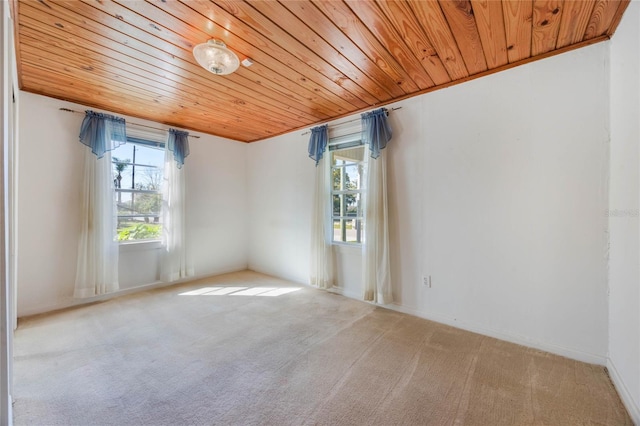 carpeted empty room featuring wooden ceiling