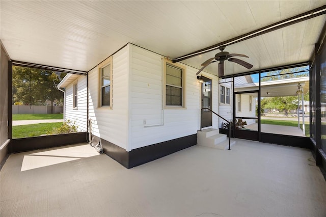 unfurnished sunroom with ceiling fan