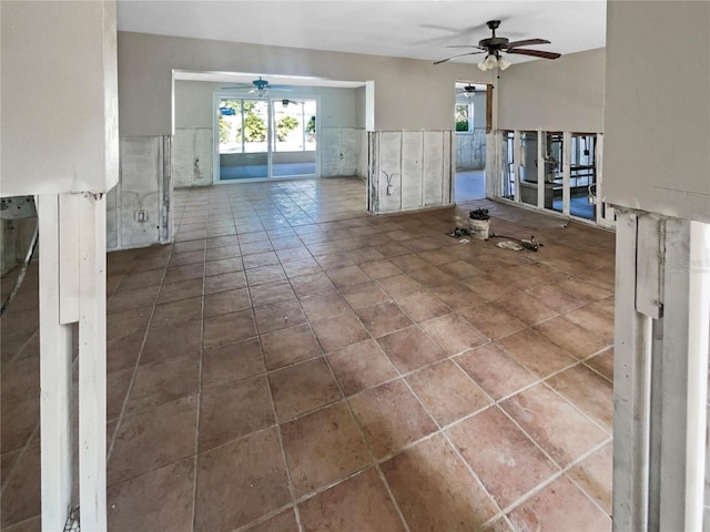 unfurnished living room with a ceiling fan and tile patterned flooring