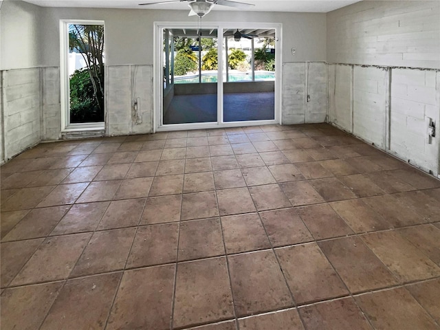 tiled empty room with plenty of natural light and ceiling fan