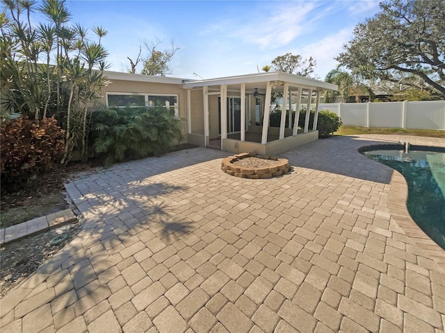 back of property featuring a patio area, a fenced backyard, a fenced in pool, and a sunroom