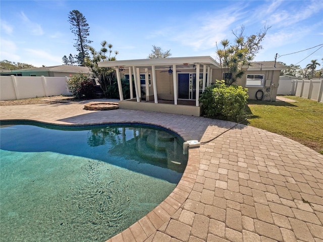 view of swimming pool featuring a fenced in pool, a fenced backyard, a sunroom, a ceiling fan, and a patio