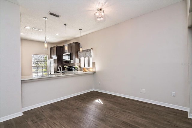 kitchen with visible vents, backsplash, light countertops, appliances with stainless steel finishes, and dark wood-style flooring