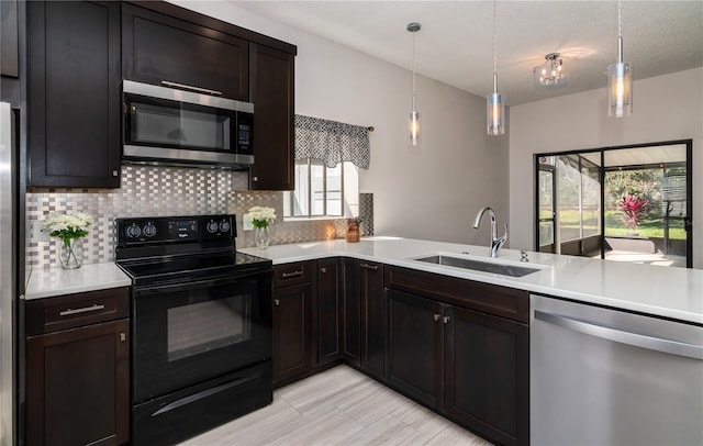 kitchen featuring a sink, light countertops, tasteful backsplash, and stainless steel appliances