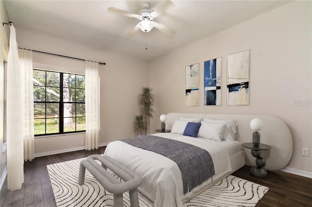 bedroom featuring ceiling fan, baseboards, and wood finished floors