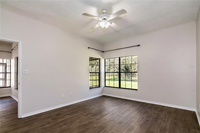 empty room featuring baseboards, a textured ceiling, ceiling fan, and dark wood-style flooring