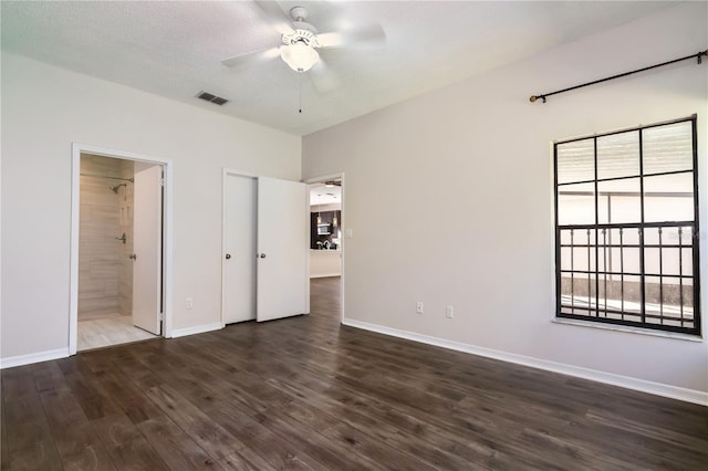 unfurnished bedroom featuring baseboards, visible vents, and dark wood-style flooring