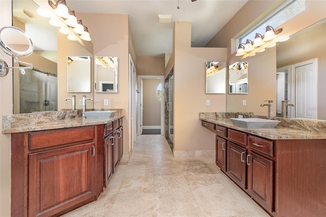 bathroom with a shower with door, two vanities, and a sink