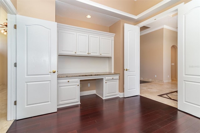 unfurnished office featuring baseboards, built in study area, dark wood finished floors, recessed lighting, and arched walkways