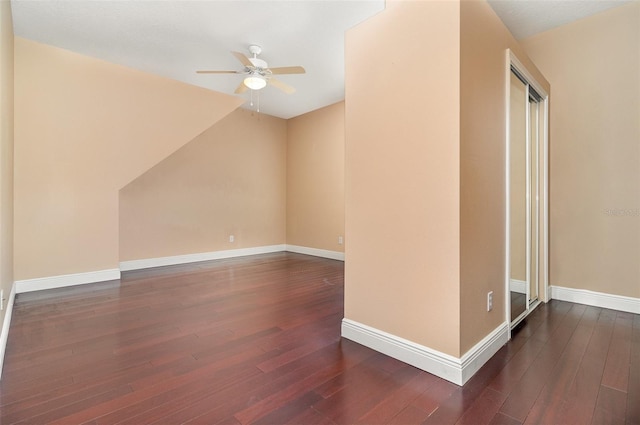 bonus room with baseboards, ceiling fan, and dark wood finished floors