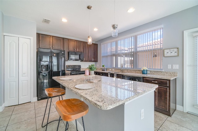 kitchen featuring a center island, dark brown cabinetry, pendant lighting, light tile patterned floors, and black appliances