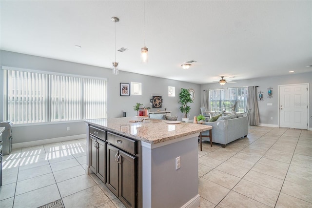 kitchen featuring visible vents, a center island, open floor plan, pendant lighting, and light tile patterned floors