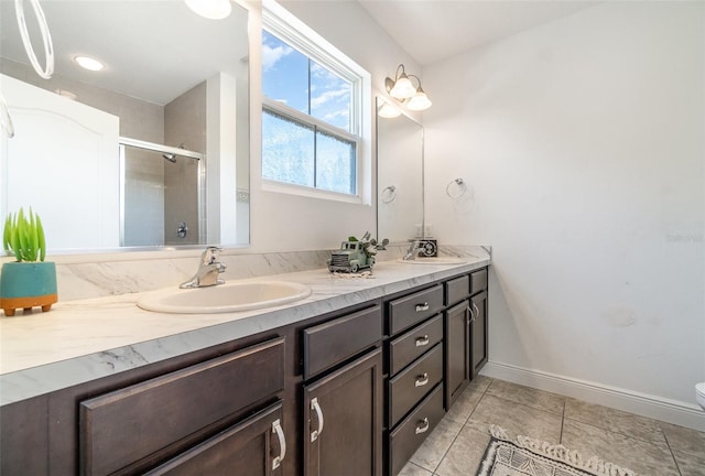 full bathroom with tile patterned flooring, double vanity, a stall shower, and a sink