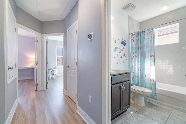 bathroom featuring vanity, baseboards, visible vents, shower / bath combination with curtain, and toilet