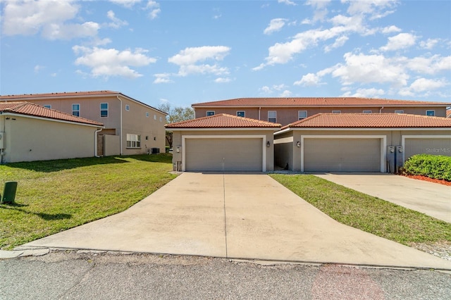 view of front of property featuring stucco siding, driveway, a front lawn, and a tiled roof