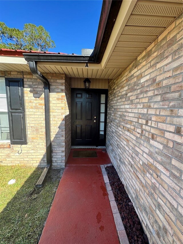 doorway to property featuring brick siding