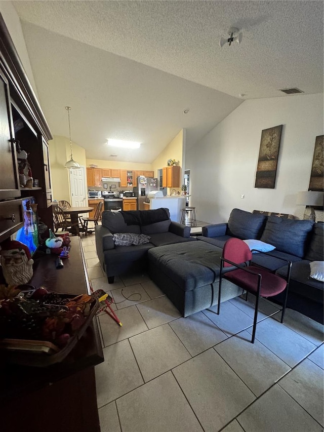 living room with lofted ceiling, light tile patterned floors, visible vents, and a textured ceiling