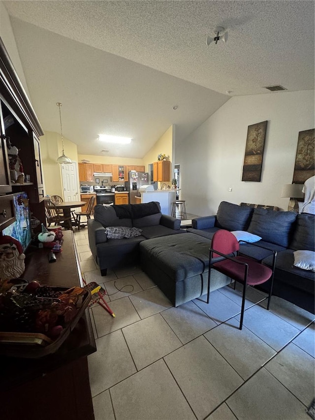 living area featuring light tile patterned floors, visible vents, a textured ceiling, and lofted ceiling