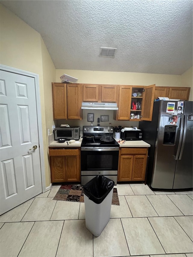 kitchen with under cabinet range hood, visible vents, brown cabinets, and stainless steel appliances