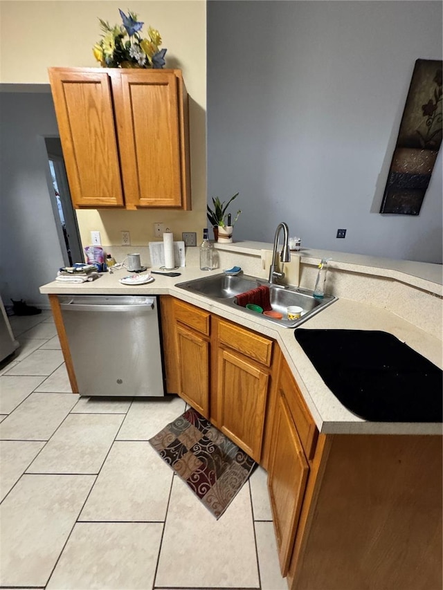 kitchen featuring a sink, stainless steel dishwasher, a peninsula, light countertops, and light tile patterned floors