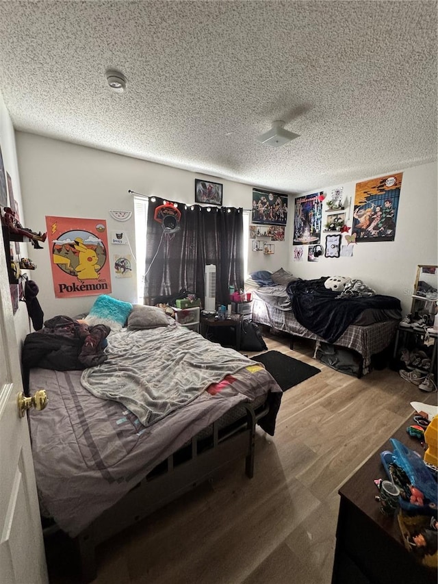 bedroom with wood finished floors and a textured ceiling