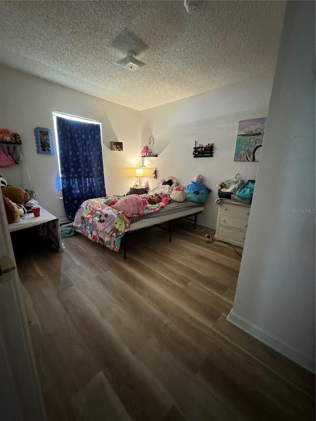 bedroom featuring wood finished floors and a textured ceiling