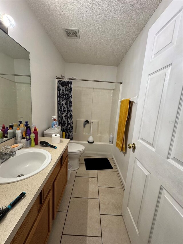 bathroom featuring tile patterned flooring, visible vents, toilet, vanity, and a textured ceiling