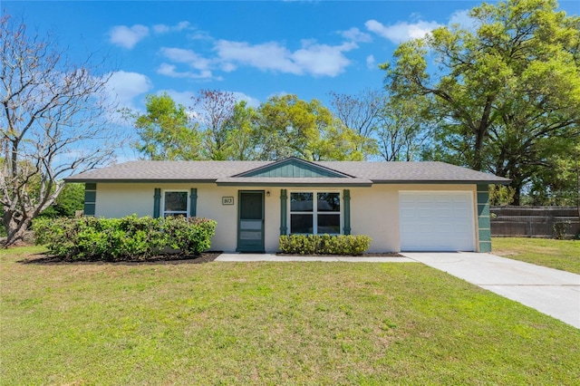 ranch-style house with stucco siding, a front yard, concrete driveway, and an attached garage