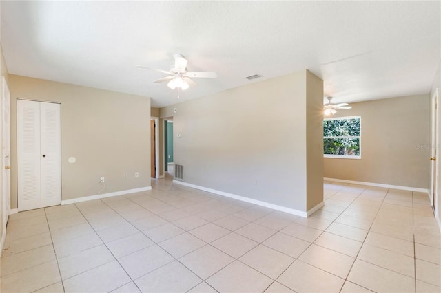 unfurnished room with light tile patterned floors, visible vents, baseboards, and a ceiling fan