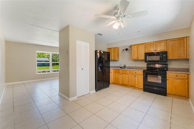 kitchen featuring baseboards, light tile patterned flooring, ceiling fan, a sink, and black appliances