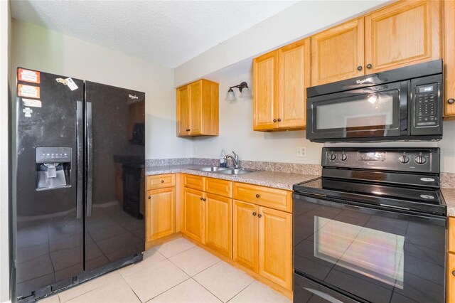 kitchen with black appliances, light countertops, light tile patterned floors, a textured ceiling, and a sink