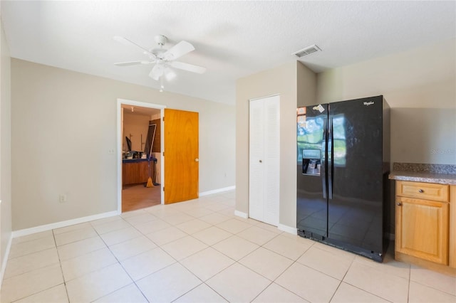 kitchen featuring ceiling fan, baseboards, visible vents, and black refrigerator with ice dispenser