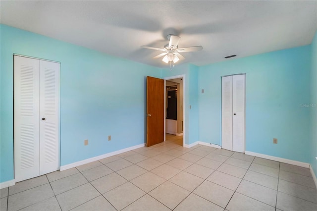 unfurnished bedroom with a closet, visible vents, baseboards, and light tile patterned flooring